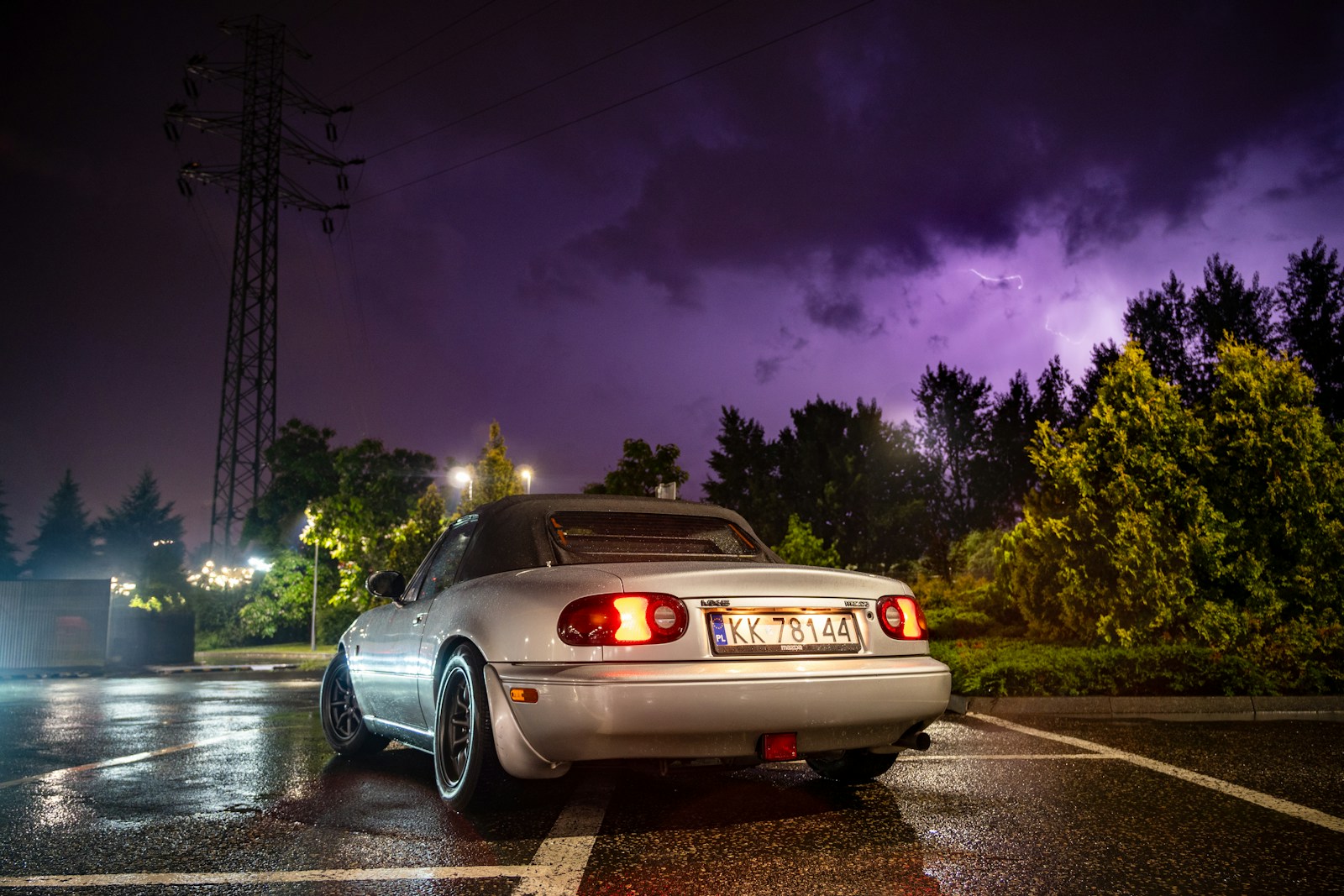 A white car parked in a parking lot at night